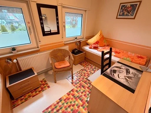 Gemütliches Monteurzimmer in Legden mit Einzelbett, Schreibtisch und Sessel für Handwerker und Geschäftsreisende.