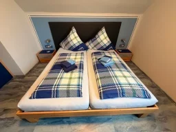 Gemütliches Doppelbett mit Nachttischen in der Pension - Gästehaus Legden für Monteure, Urlauber und Radfahrer.