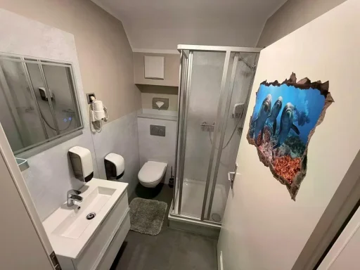 Sauberes, modernes Badezimmer mit Dusche, WC und Waschbecken in der Pension - Gästehaus Legden.