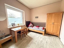 Gepflegtes Einzelzimmer in Legden mit Holzschrank, Bett und Schreibtisch für Urlauber und Monteure.