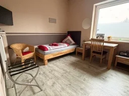 Günstiges Einzelzimmer in Legden mit Bett, Schreibtisch, Fernseher und Sessel für Monteure und Geschäftsreisende.