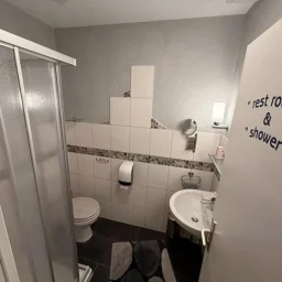 Helles Badezimmer mit Dusche, WC und Waschbecken in der Pension - Gästehaus Legden.