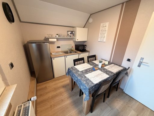 Gemütliche Kochecke mit Kühlschrank, Mikrowelle und Esstisch zur Selbstversorgung für Monteure in der Pension Legden.