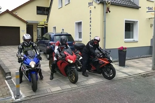 Drei Motorradfahrer auf ihren Maschinen vor der Pension Gästehaus Legden im Münsterland.