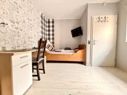 Zimmer mit Bett, Fernseher und Schreibtisch für Monteure in der Pension Legden.