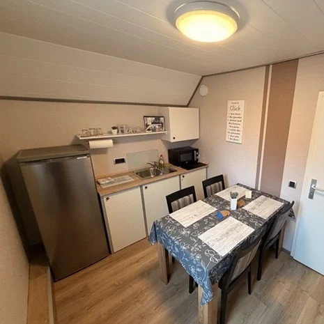 Gemütliche Teeküche mit Kühlschrank, Mikrowelle und Esstisch für Gäste in Legden.