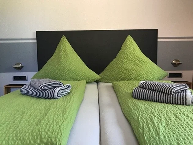 Bezogenes Doppelbett mit Handtüchern für Urlauber und Gäste in der Pension - Gästehaus Legden.